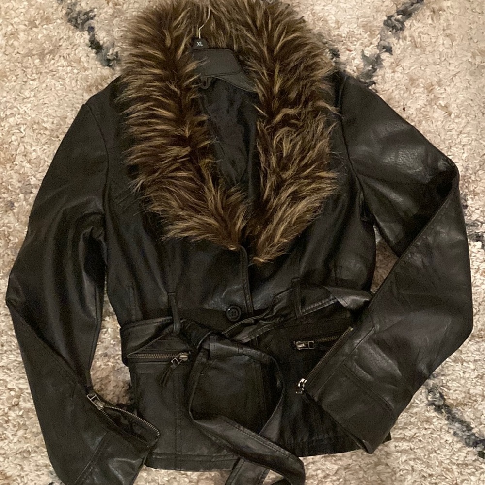 Black, faux leather with fake fur collar. Very cute !